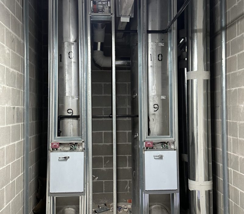 Dual trash chute system inside a concrete shaft
